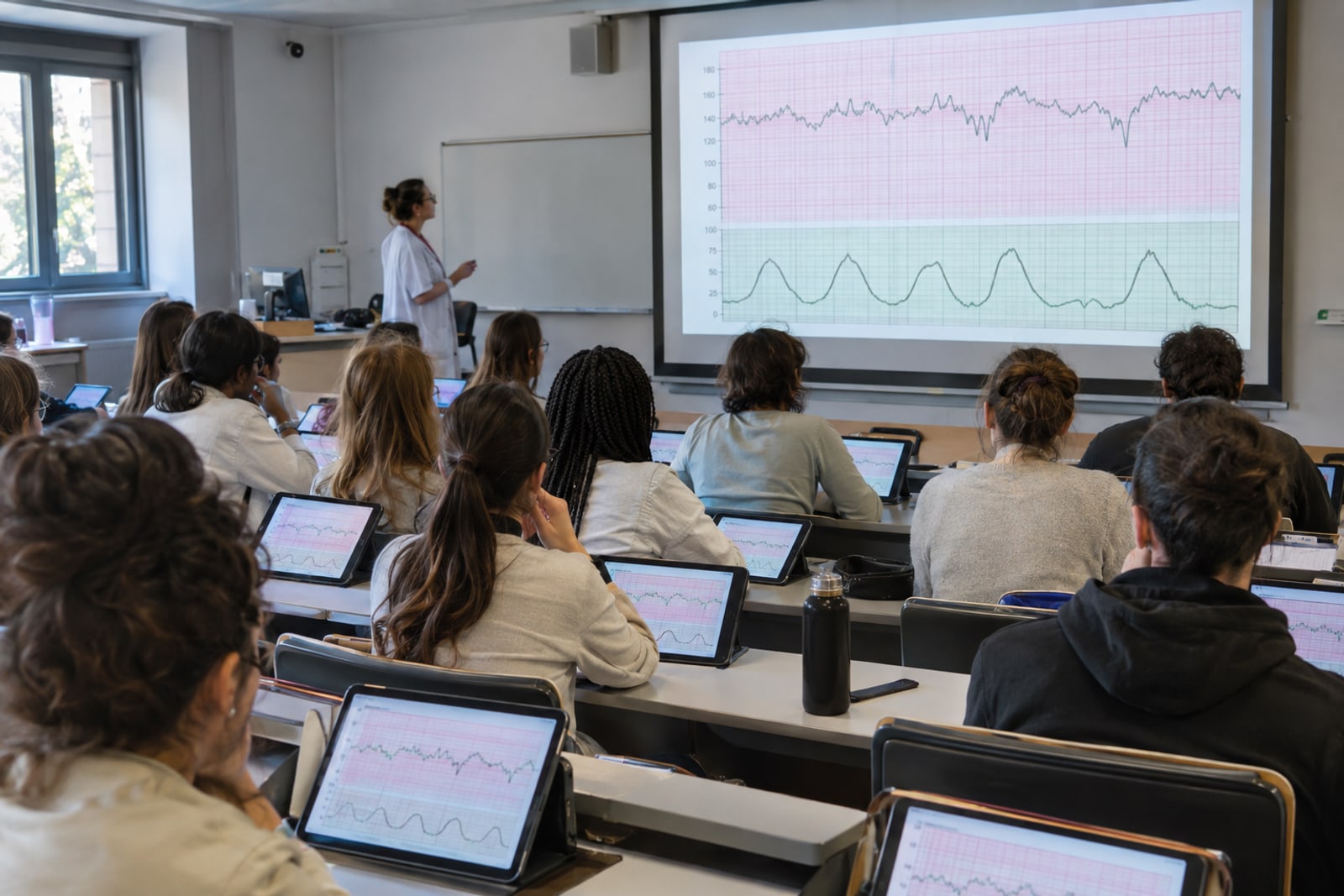 © Image générée avec ChatGPT pour eRCF Midwifery students analysing on their tablets the same CTG trace as the one projected by the teacher